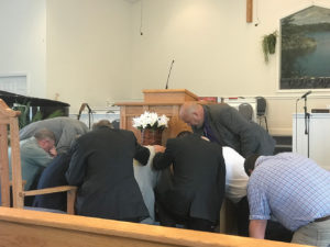 Praying around Steve at ordination service.