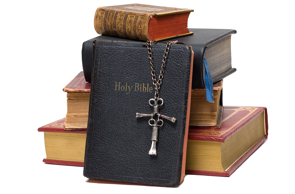 Stack of bibles with cross necklace draped across.