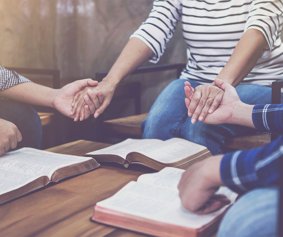 People holding hands during bible study.