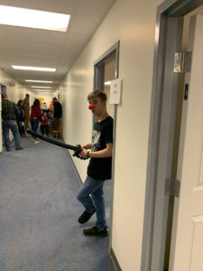 Ian holding a balloon sword and wearing a clown nose.